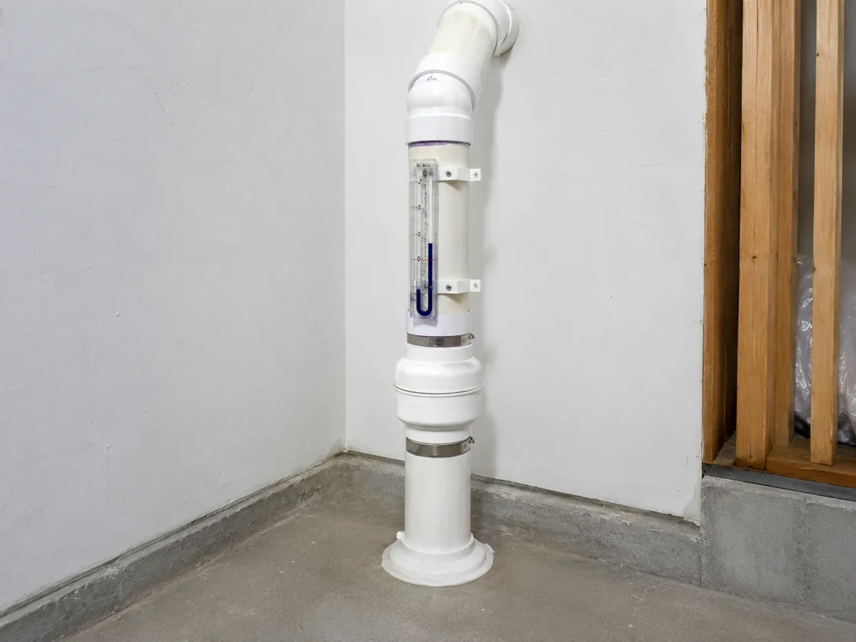 Radon mitigation system pressure indicator and piping